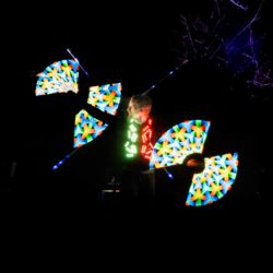 LED Jongleur spielt mit zwei leuchtenden staeben