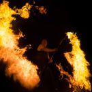 Feuerkünstler dreht einen brennenden Stab mit riesen Flammen
